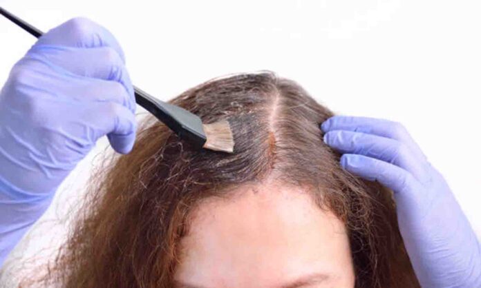 Close-up a brunette woman dying her hair with white background té negro canas